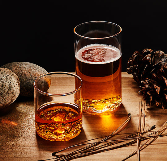 glassware filled with drinks on wooden table and romantic lighting